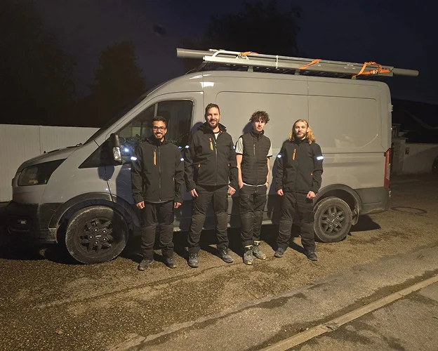 Quatre hommes devant une camionnette grise avec une échelle sur le toit, de nuit à Saint-Pathus près de Meaux en Seine-et-Marne 77