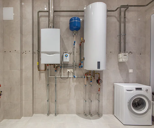 Salle de services avec chaudière, chauffe-eau, et lave-linge sur carrelage clair à Saint-Pathus près de Meaux en Seine-et-Marne 77