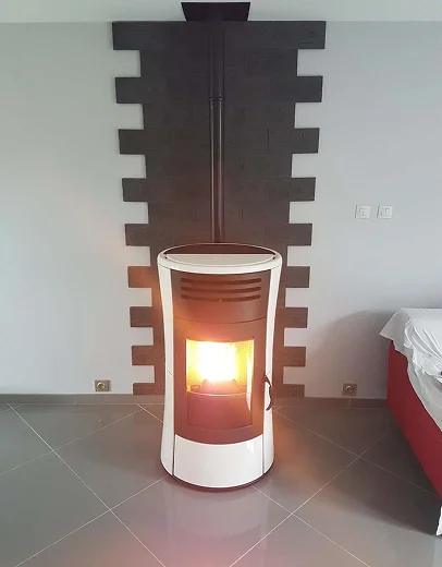 Poêle à granulés blanc allumé devant un mur gris et une cheminée décorative noire à Saint-Pathus près de Meaux en Seine-et-Marne 77