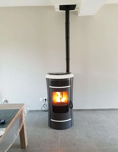Poêle à granulés anthracite avec flammes visibles, raccordé à la cheminée, dans un intérieur moderne à Saint-Pathus près de Meaux en Seine-et-Marne 77