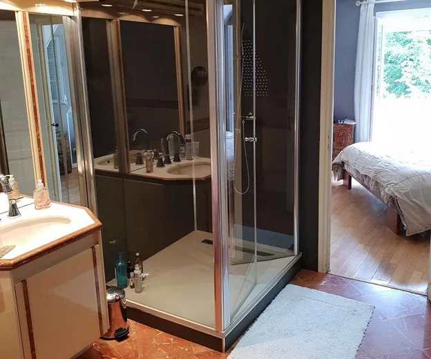 Salle de bain avec double vasque, douche en verre, et chambre adjacente à Saint-Pathus près de Meaux en Seine-et-Marne 77